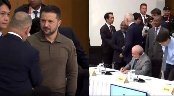 Lula sentado à mesa, não cumprimenta Zelensky .