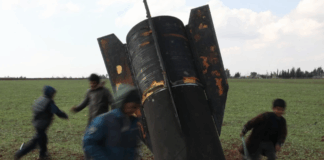 Crianças brincam com míssil não detonado na Síria, país afetado por guerra