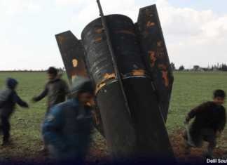 Crianças brincam com míssil não detonado na Síria, país afetado por guerra