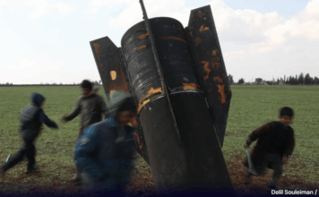 Crianças brincam com míssil não detonado na Síria, país afetado por guerra